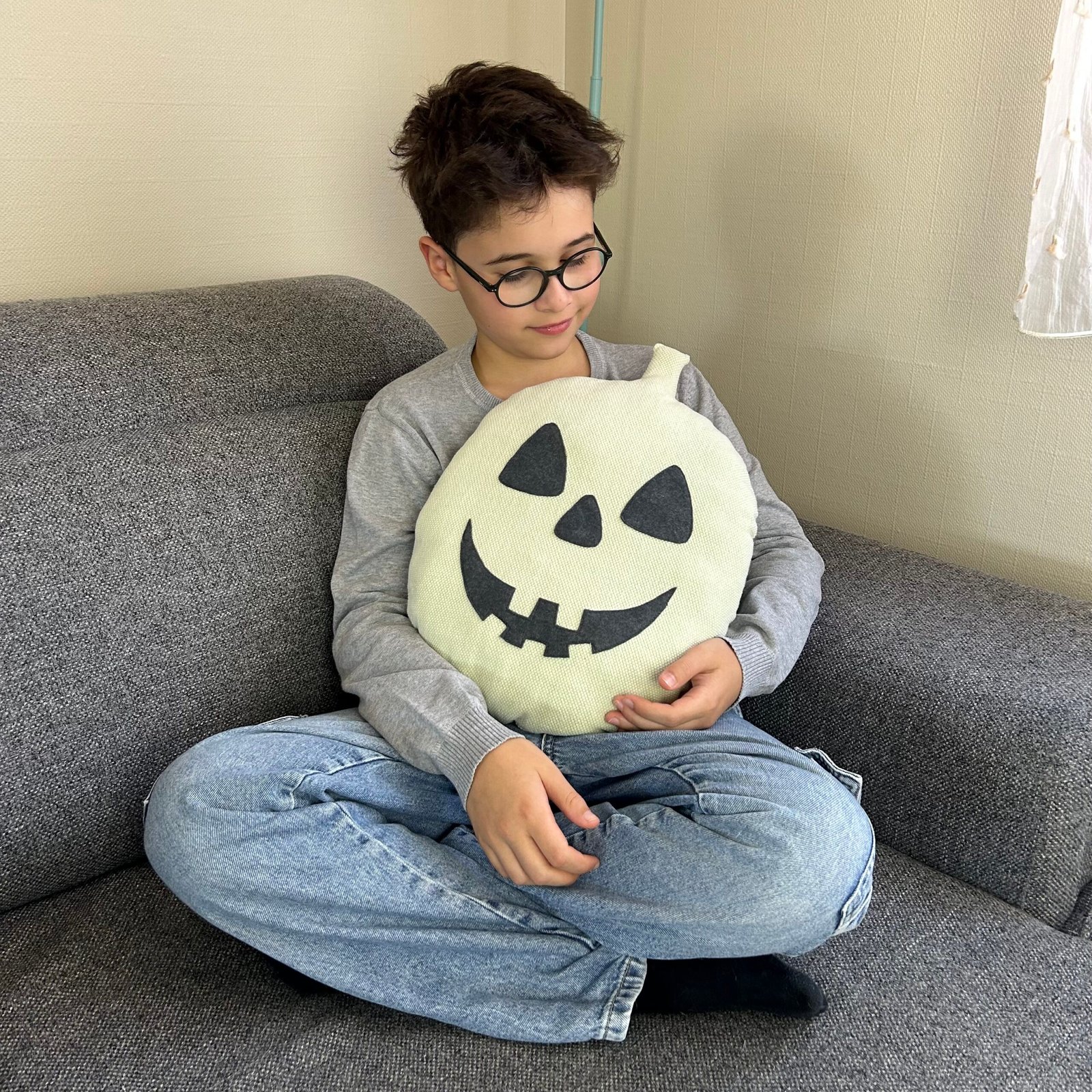 Deuxième coussin citrouille rond tenu dans les bras par un enfant