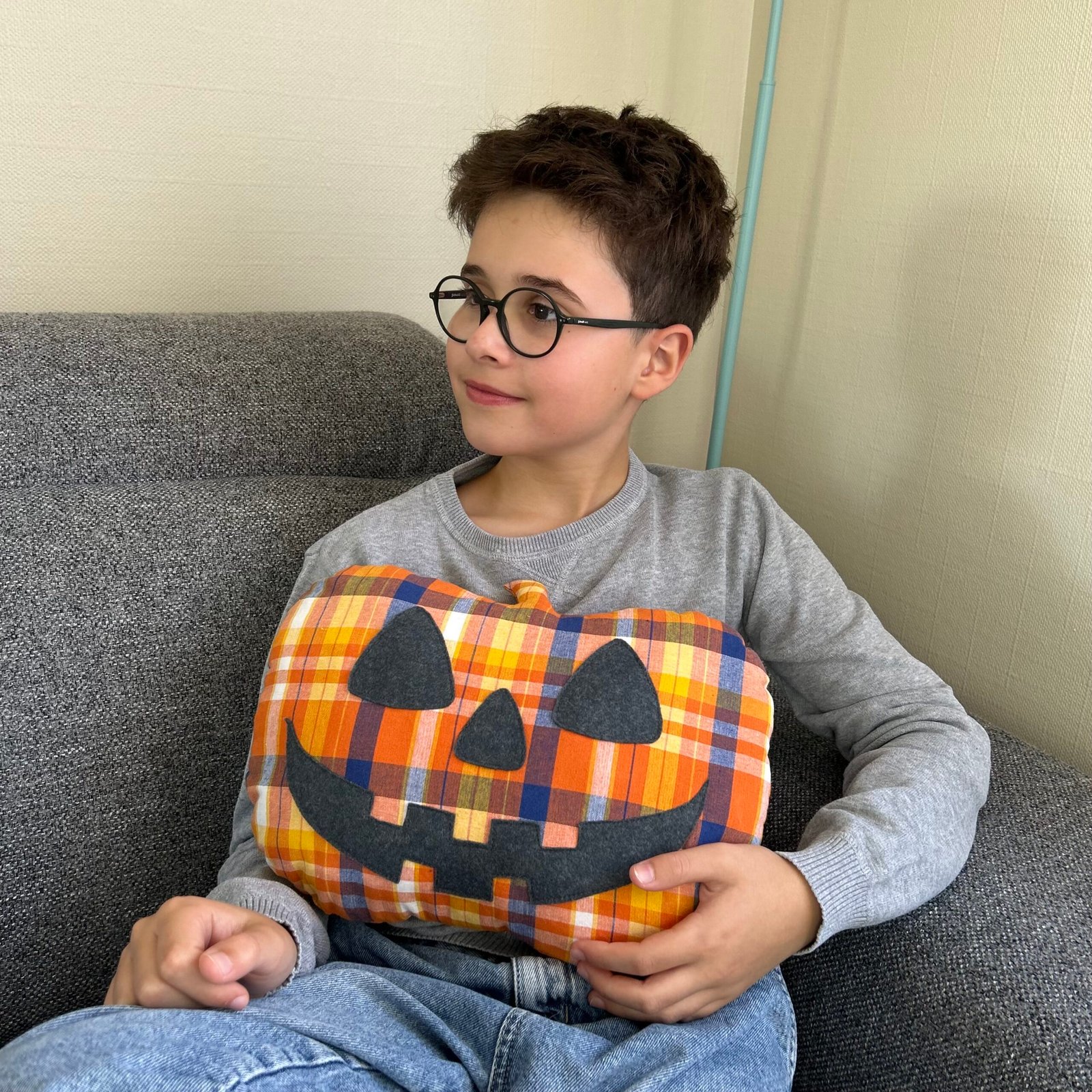Premier coussin citrouille du patron Les Trois Citrouilles tenu dans les bras par un enfant